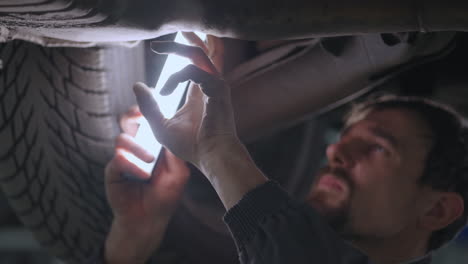 Close-up-of-the-hand-The-mechanic-inspects-the-exhaust-system-of-the-car-in-the-car-service.-Car-on-the-lift-inspection-and-diagnosis-of-problems-with-the-suspension-of-the-car